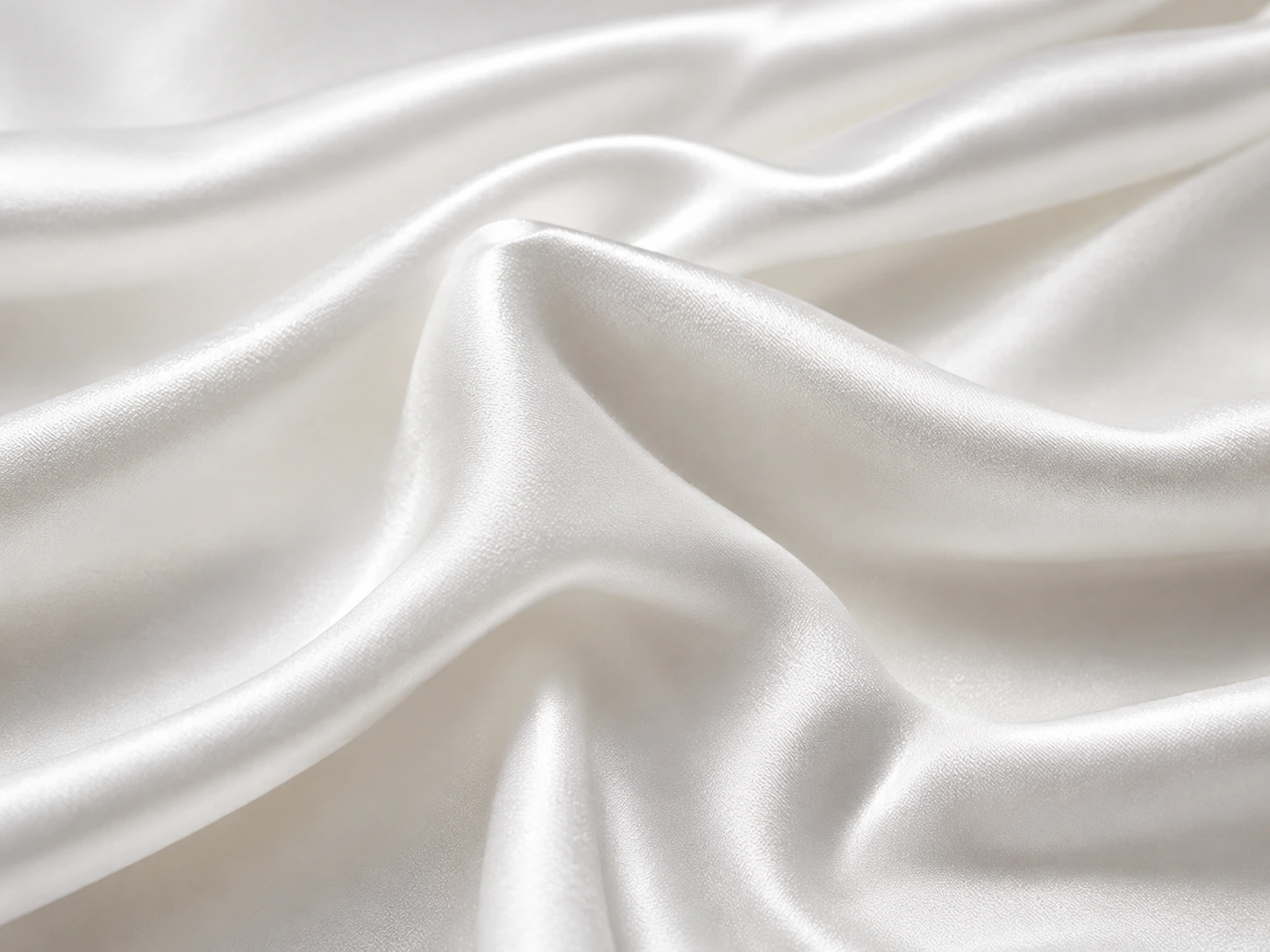 White silk charmeuse fabric closeup with fluid drape and glossy texture