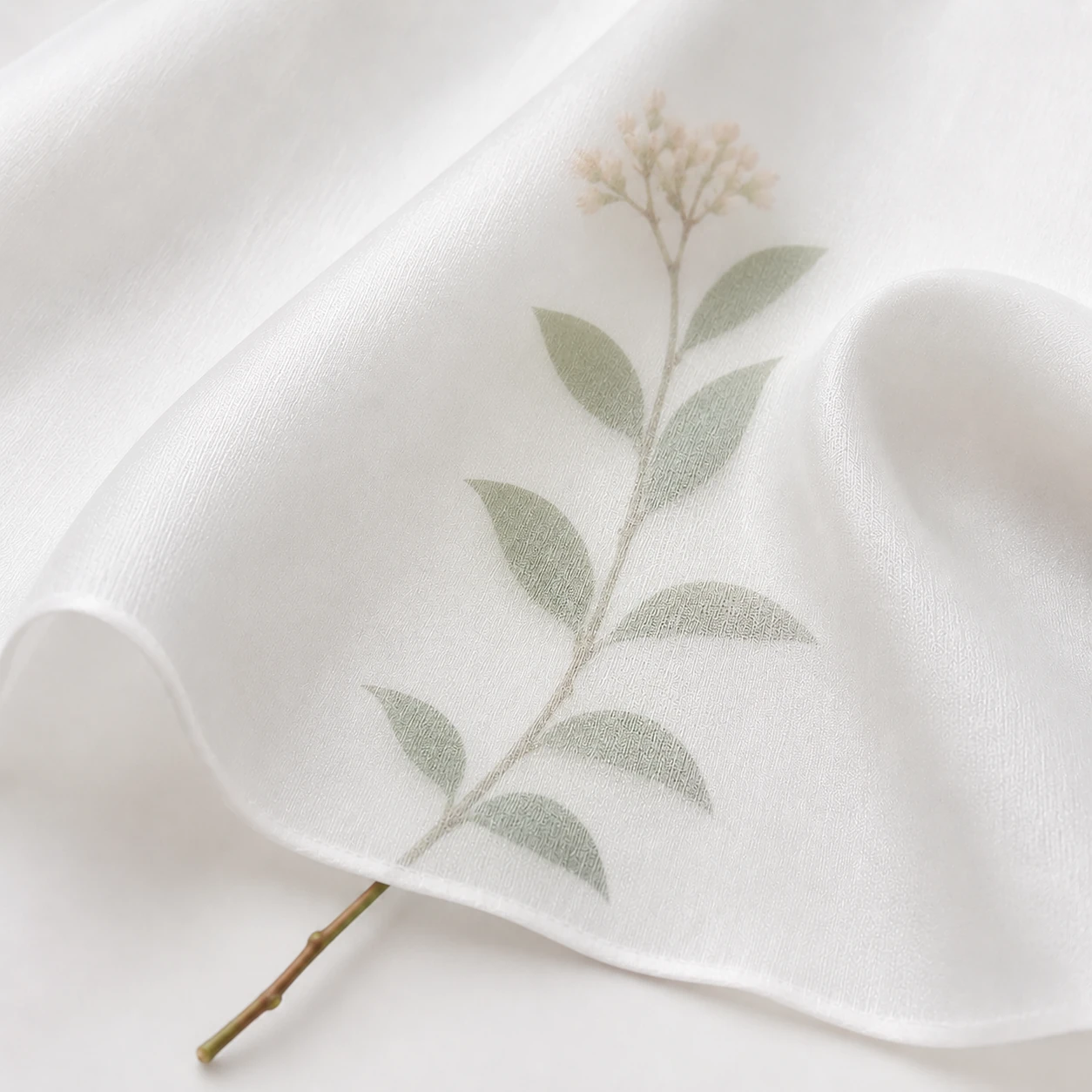 White silk twill fabric detail with a soft natural leaf silhouette visible through the fabric.