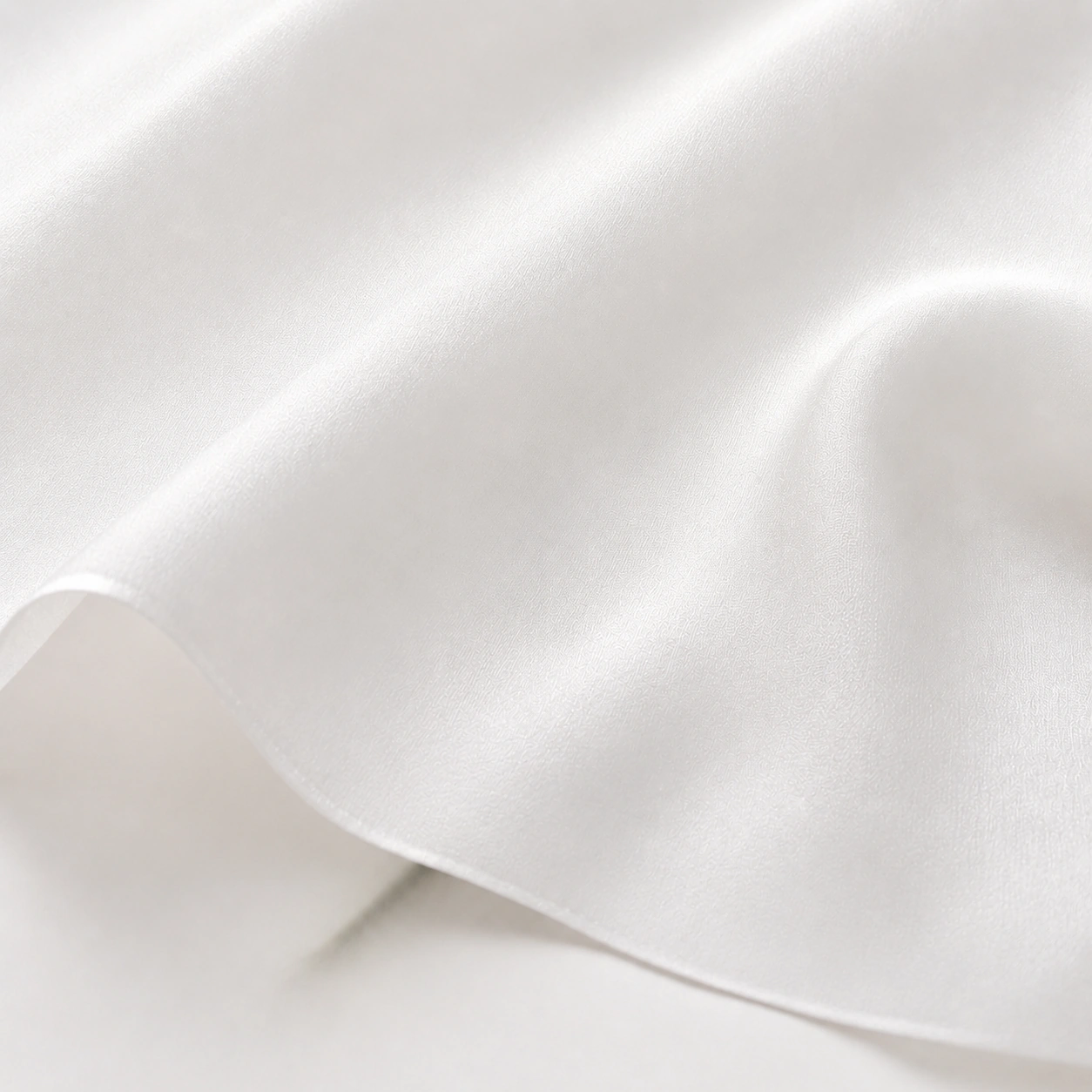 Close-up of white silk twill fabric with refined texture and a very soft transparent effect.