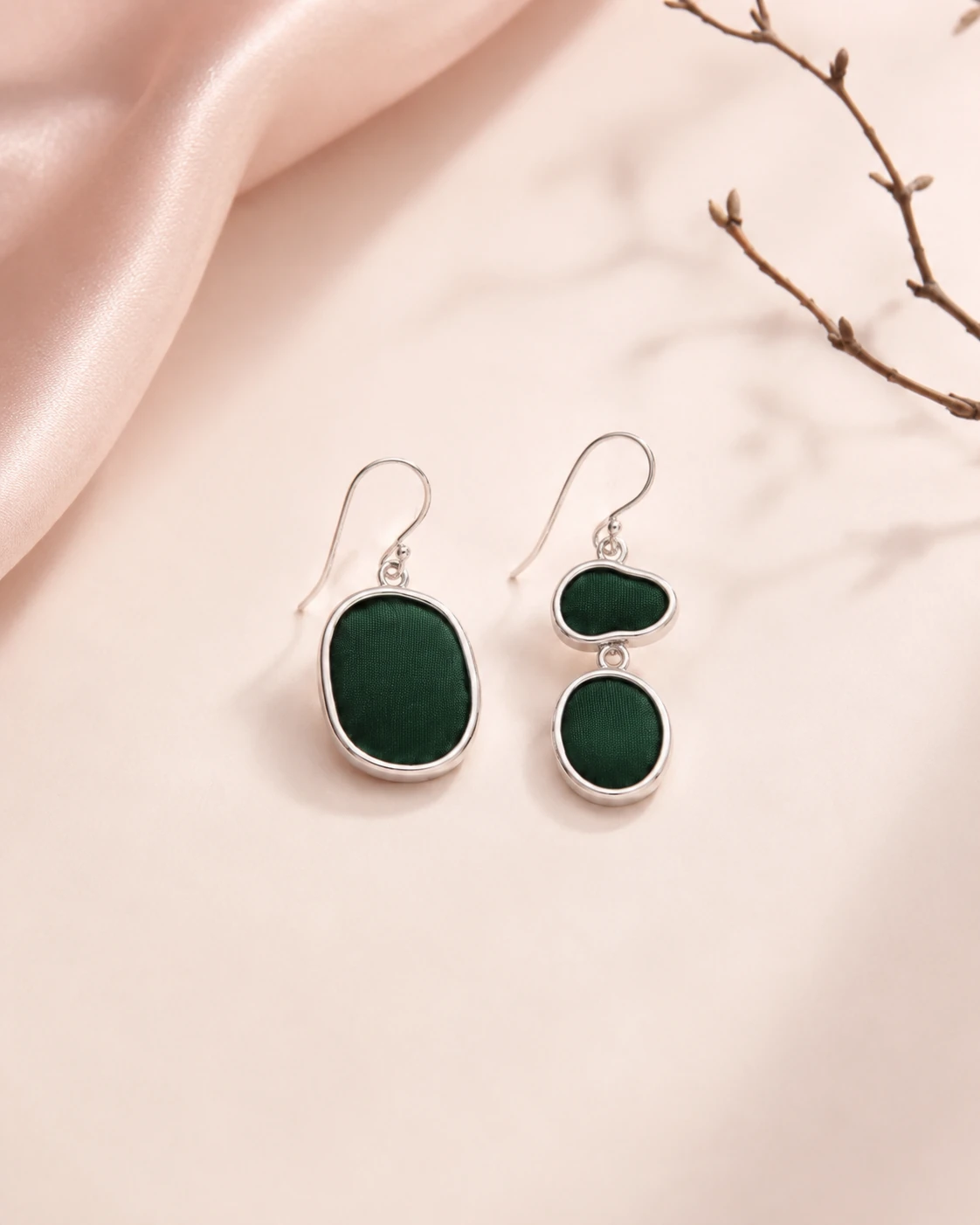 Asymmetrical earrings with irregular oval dark green silk pieces and silver-tone frames