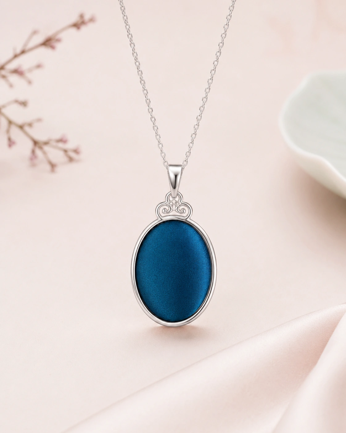 Oval pendant necklace with solid peacock blue silk and decorative silver-tone setting