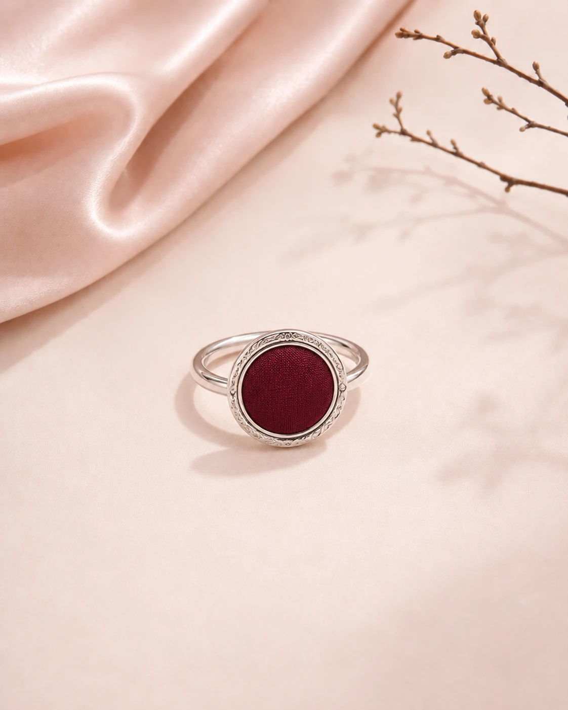Round ring with solid burgundy silk center and decorative silver-tone metal border